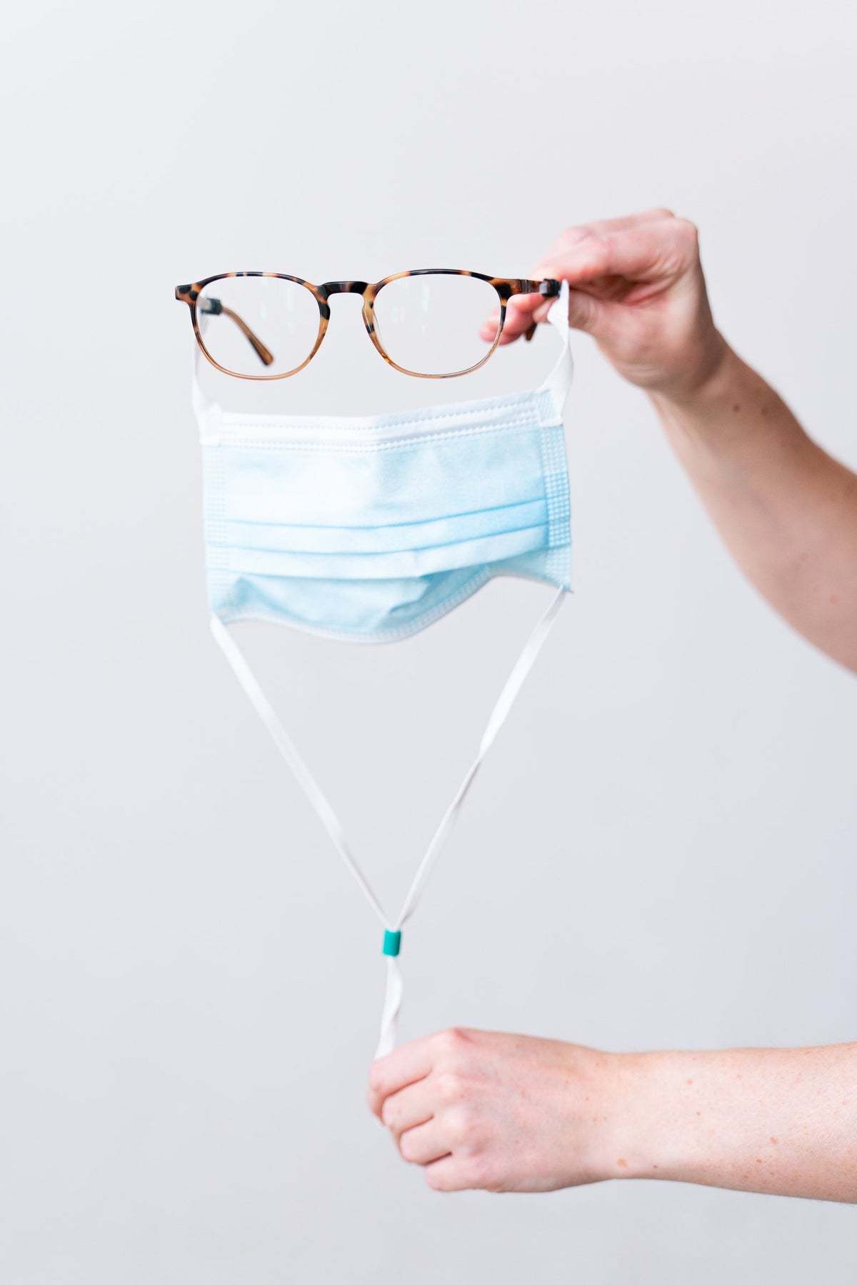 SLEEVZ mask hanging from eyeglasses by its Quick Connects