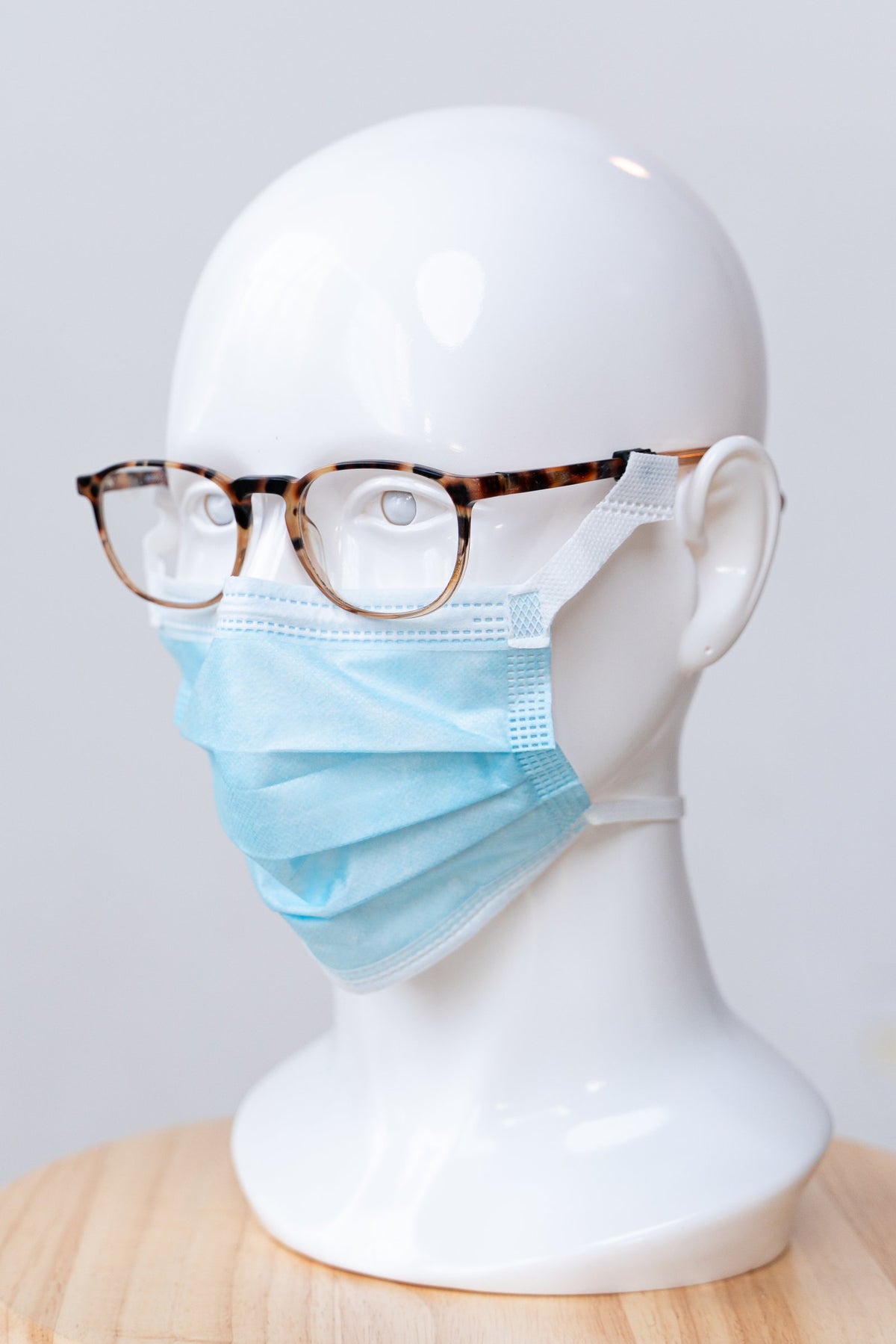 SLEEVZ disposable mask attached to eyeglasses on a display head